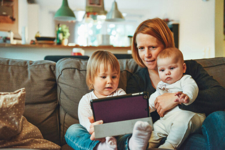 Mother with 2 children watching tablet Exterminator Near Me